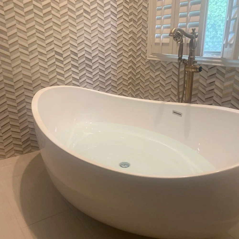 Freestanding tub against a chevron tile wall