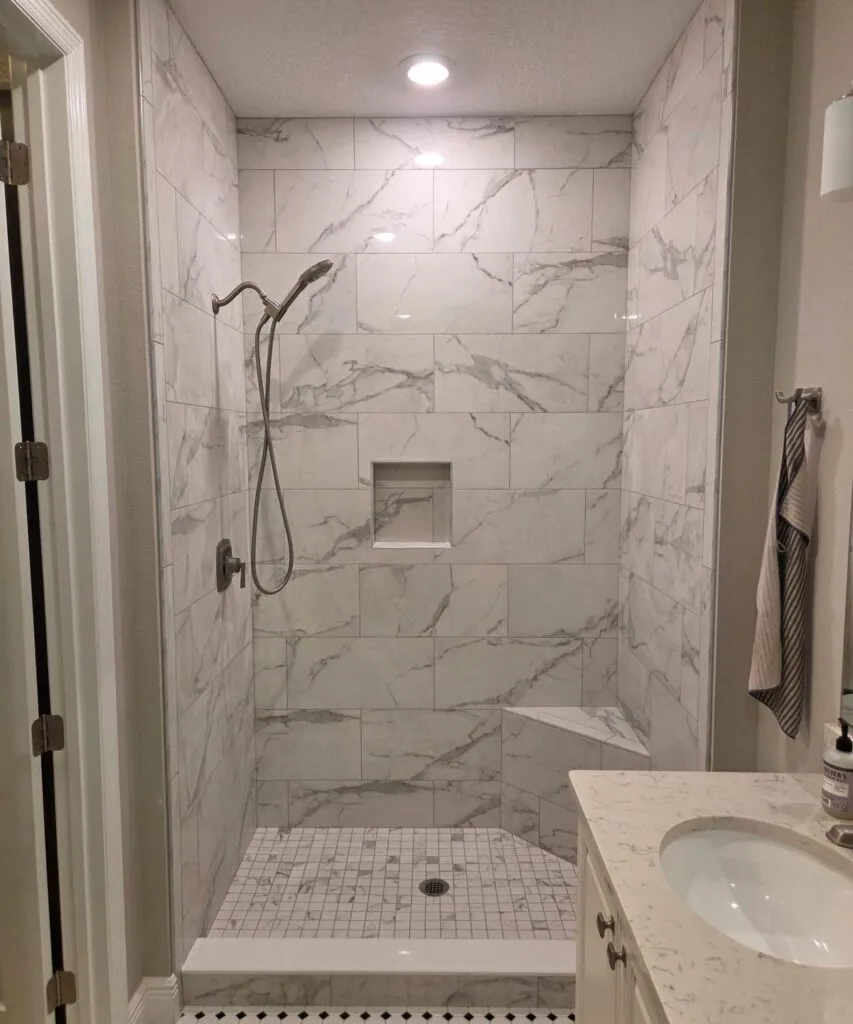 Full bathroom marble tile installation with shower and vanity