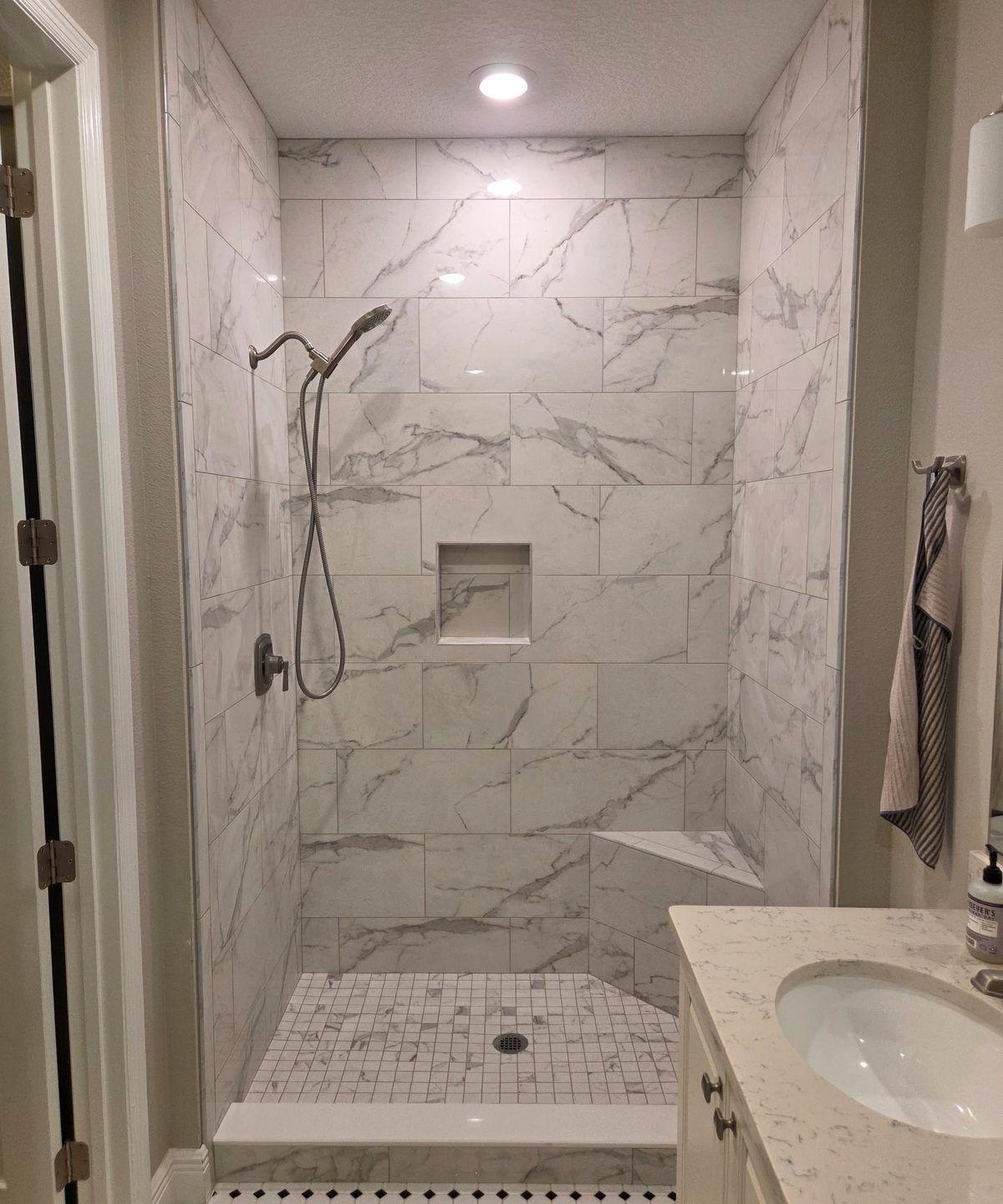 Full bathroom marble tile installation with shower and vanity