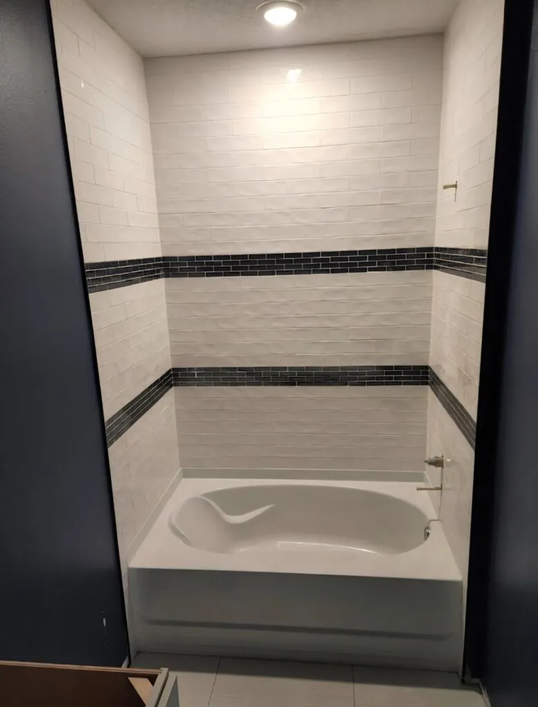 Tiled tub surround with a dark accent band