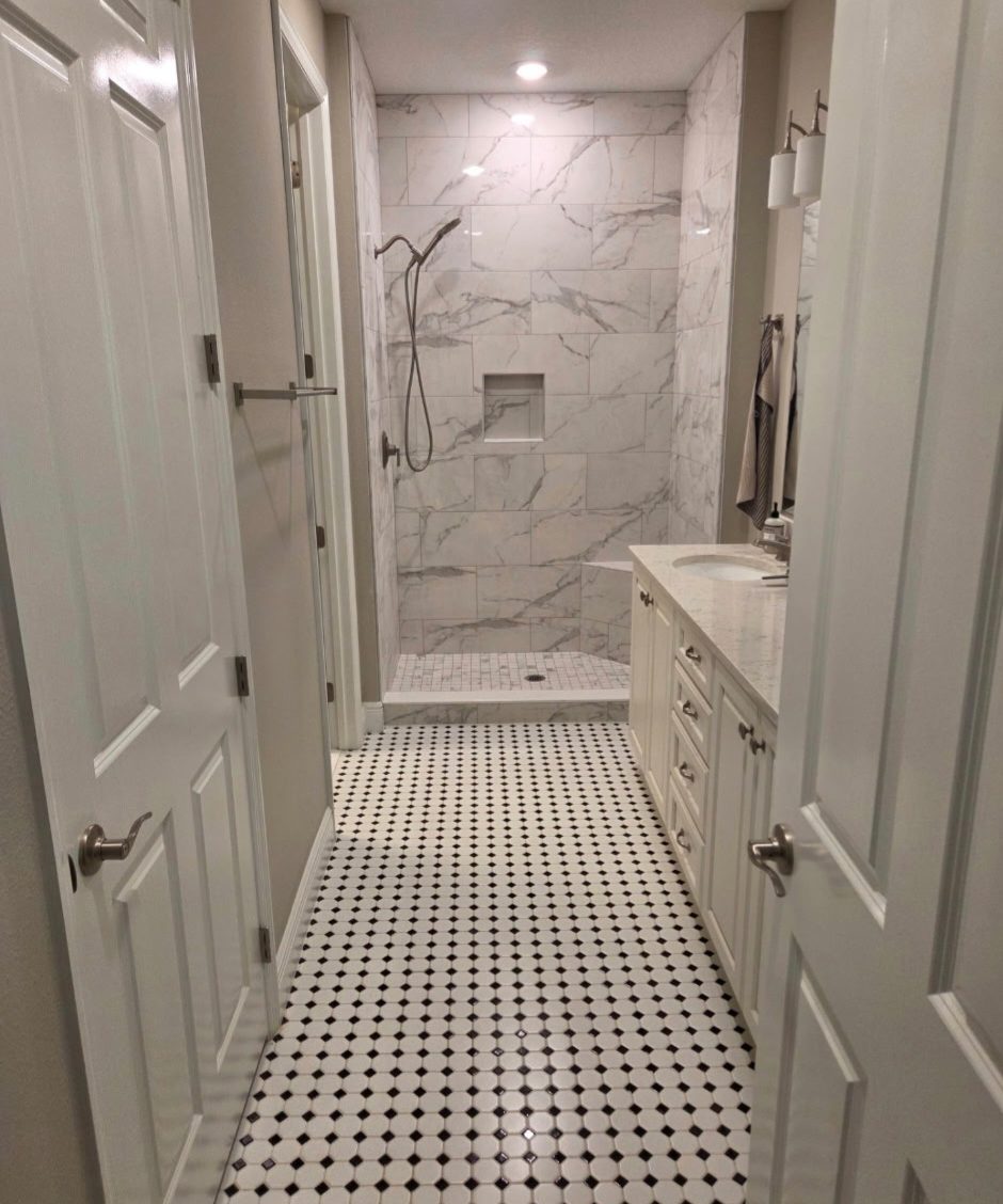 Black and white mosaic floor tile in a bathroom hallway