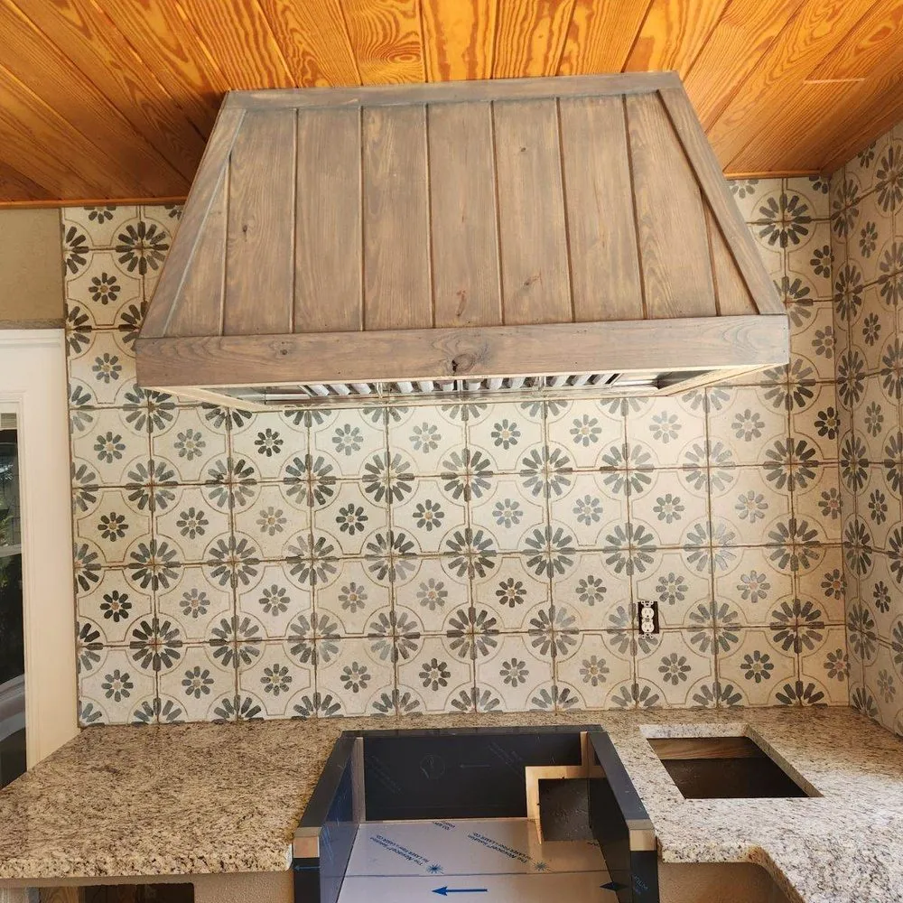 Patterned cement-look kitchen backsplash under a wood hood