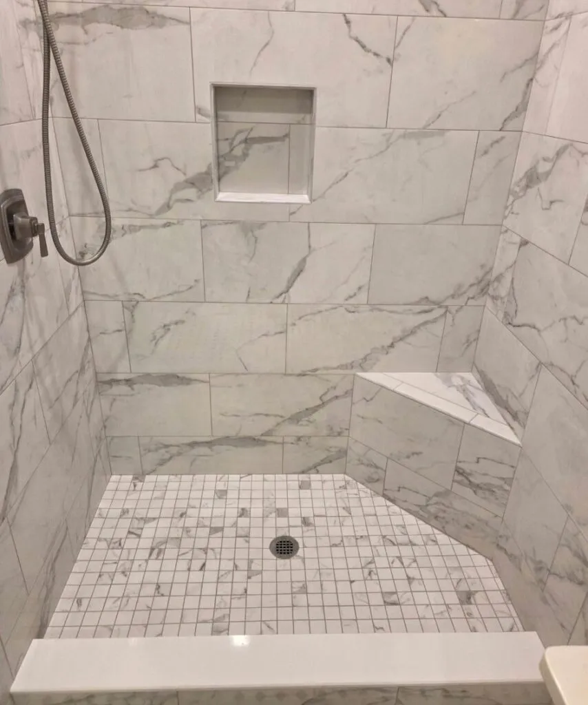 Sloped shower pan finished in mosaic tile
