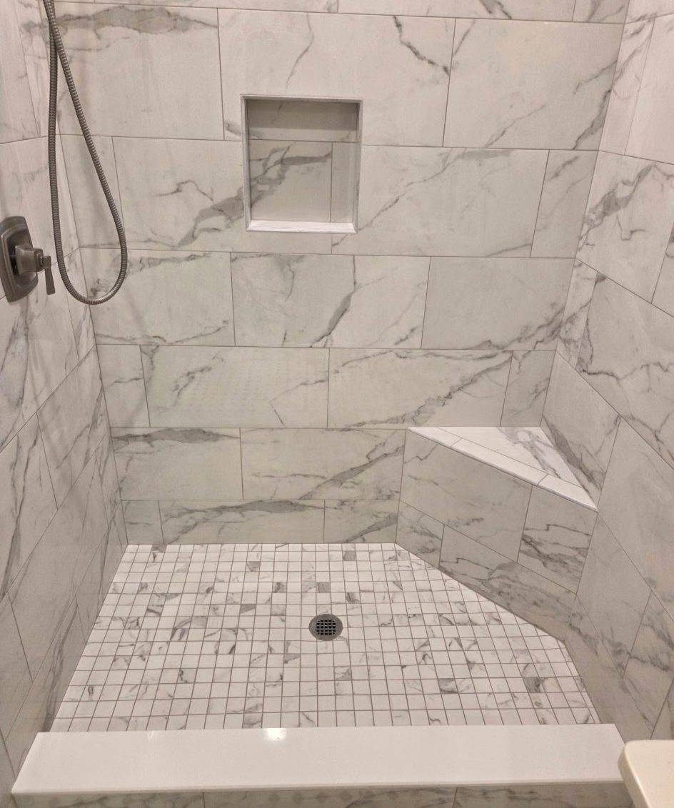 Sloped shower pan finished in mosaic tile