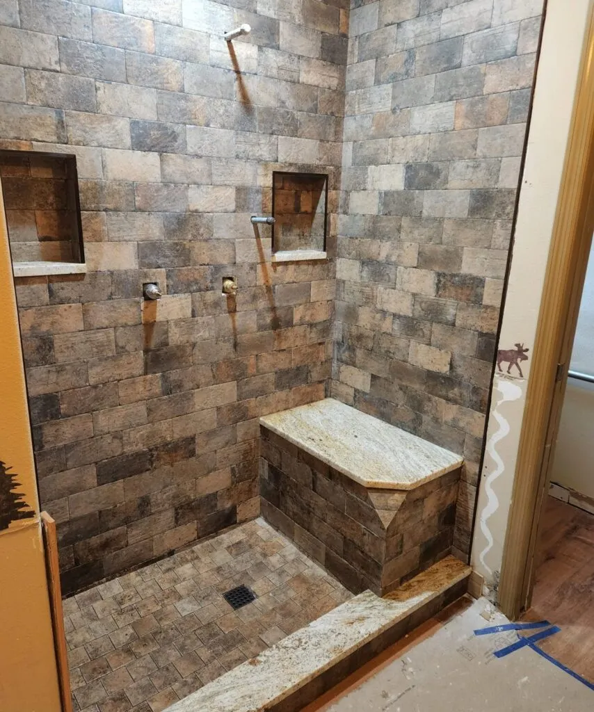 Stone tile shower with a built-in bench