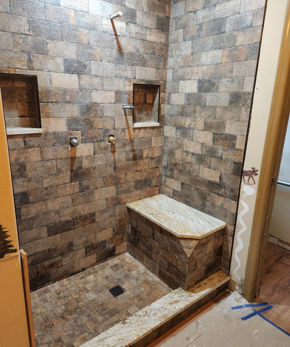 Stone tile shower with a built-in bench