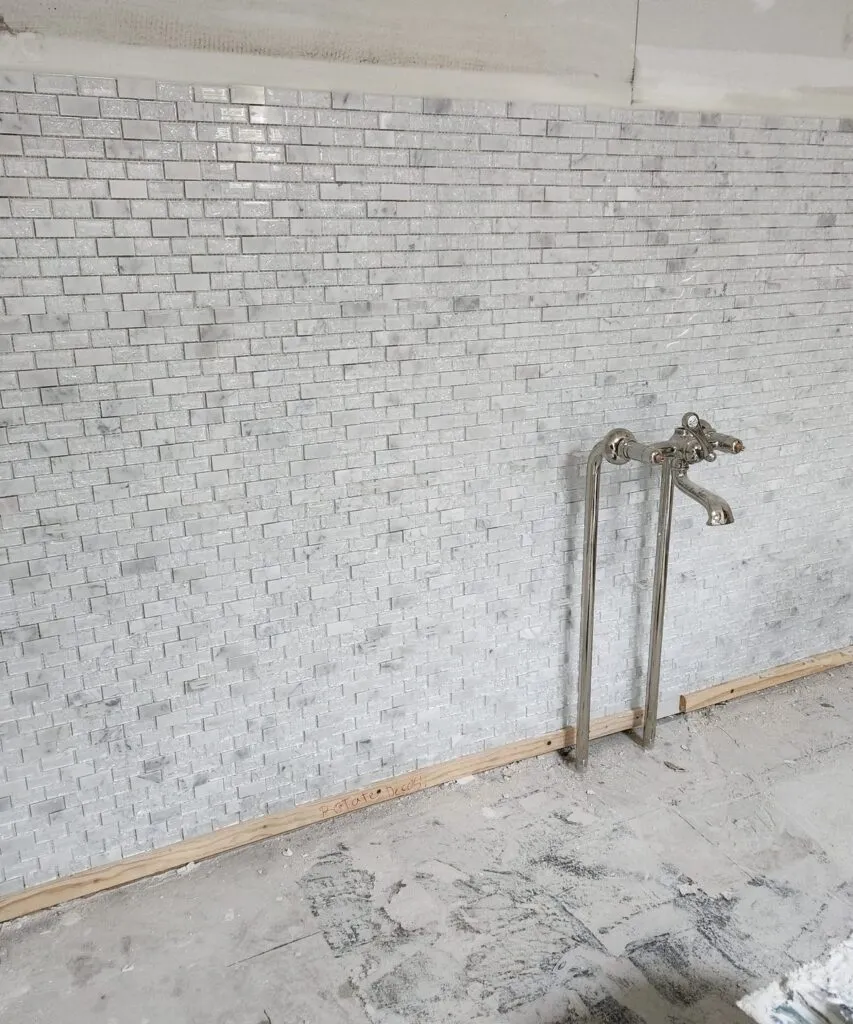 Tile installation in progress on a shower wall