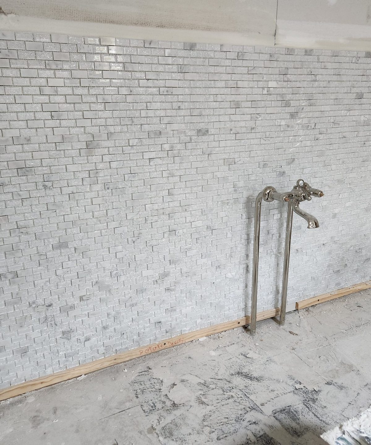 Tile installation in progress on a shower wall