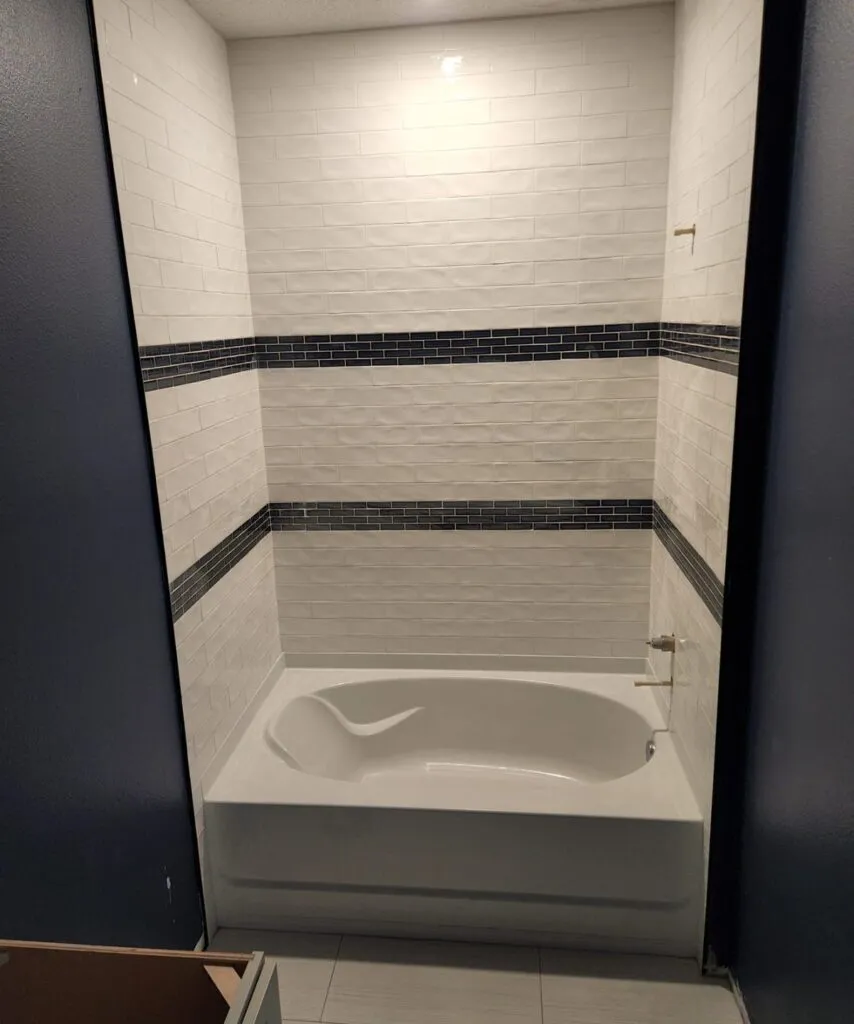 Tub and shower surround finished in tile with an accent band